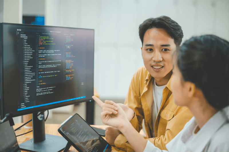 Developers collaborating over API integration code on screen
