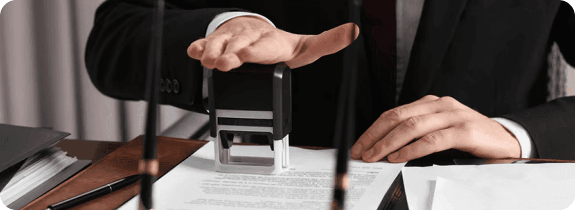 Person stamping official document on a desk