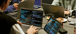 Developers working with laptops and multiple screens