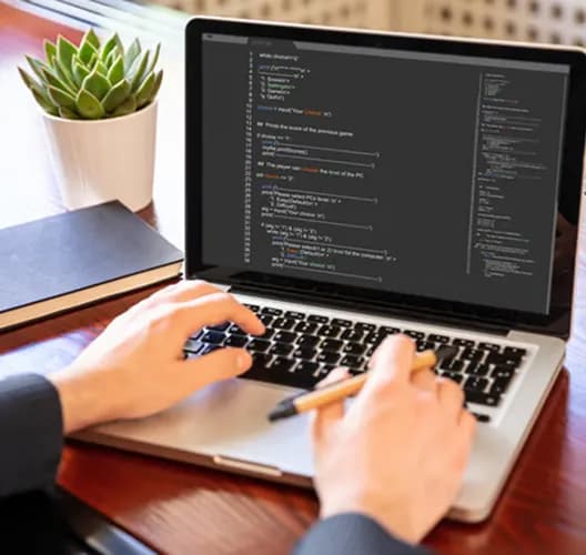 Developer writing code on a laptop