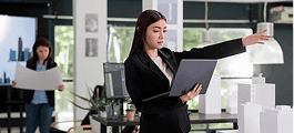 Woman holding architectural drawings in office