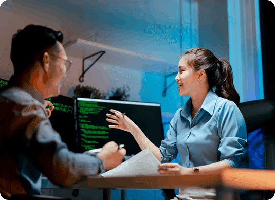Two professionals discussing technical details at a workstation