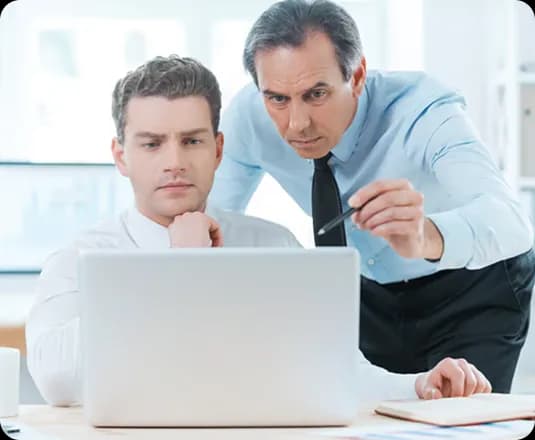 Two colleagues reviewing an asset page on a laptop