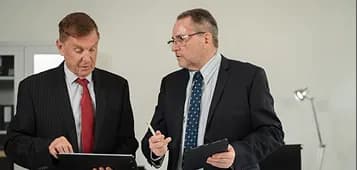 Two executives reviewing a tablet together