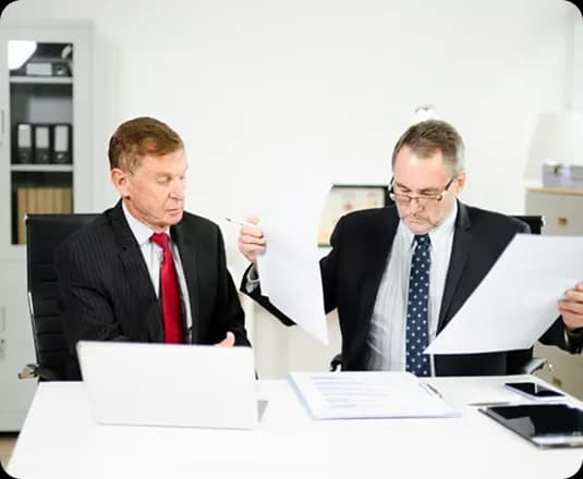 Two colleagues reviewing documents at a desk