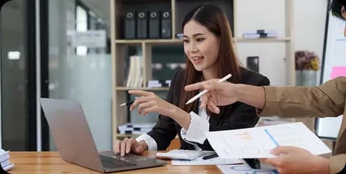 Reviewer discussing a request at a laptop